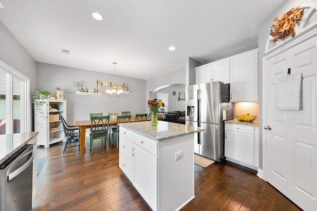 kitchen featuring stainless steel appliances, a center island, white cabinets, and hanging light fixtures