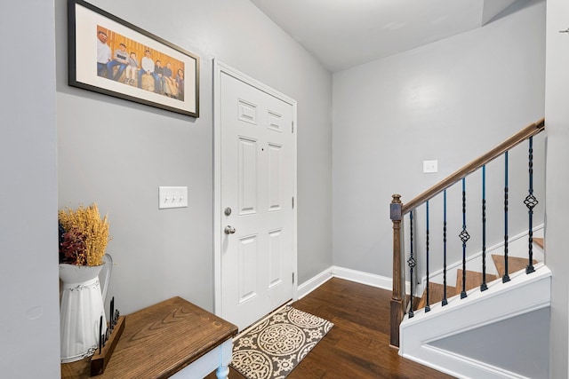 entrance foyer featuring stairs, baseboards, and dark wood finished floors