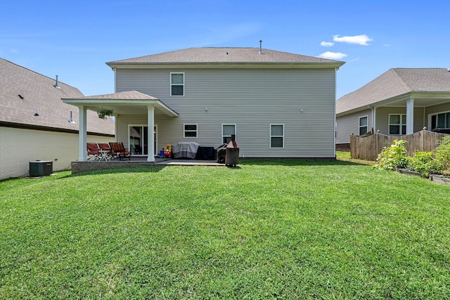 rear view of property with a patio area, fence, a lawn, and central AC