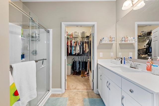 bathroom featuring vanity, a shower stall, and a spacious closet