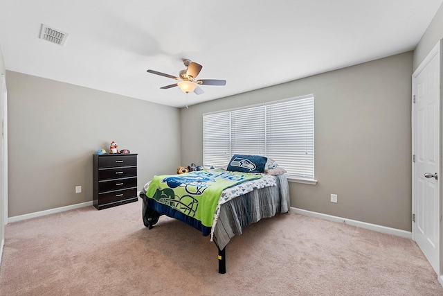 bedroom with a ceiling fan, light colored carpet, visible vents, and baseboards