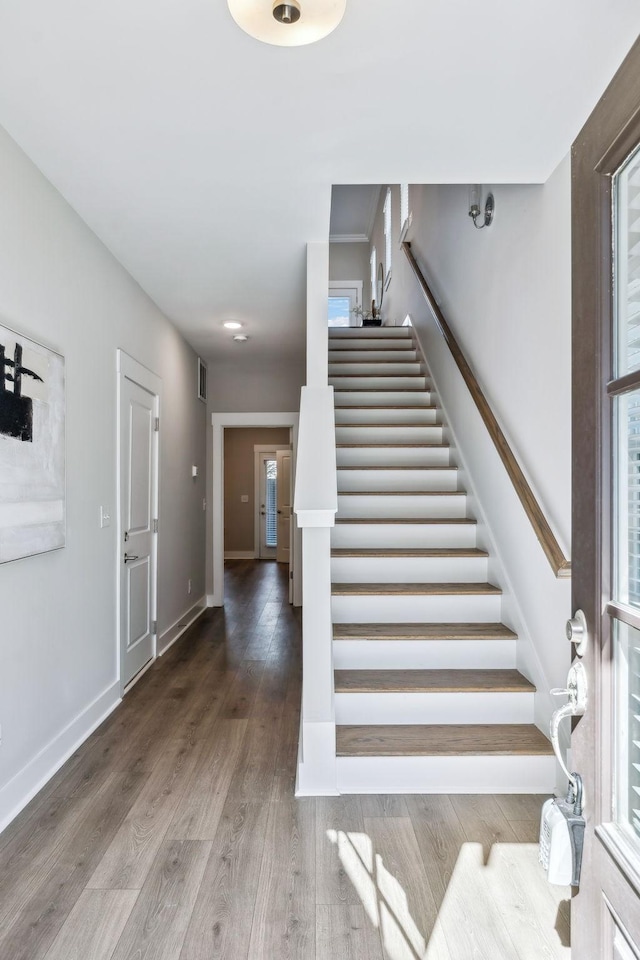 entrance foyer with wood finished floors, baseboards, and stairs