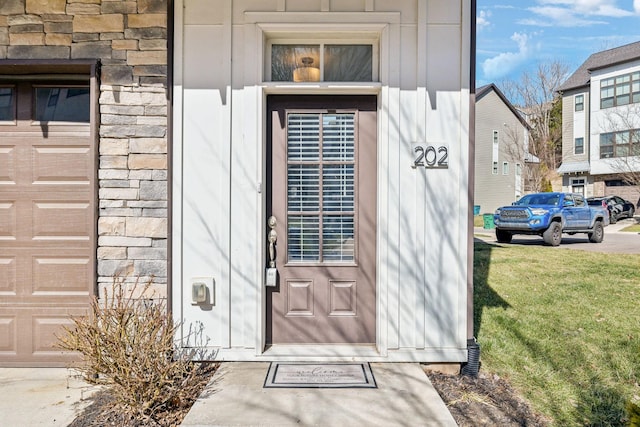 entrance to property with a garage and stone siding