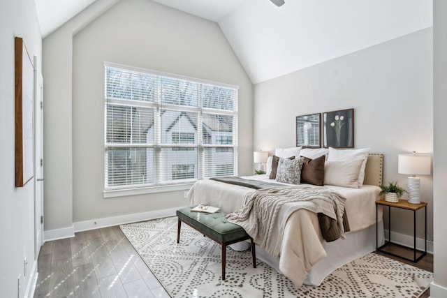 bedroom with baseboards, vaulted ceiling, and wood finished floors