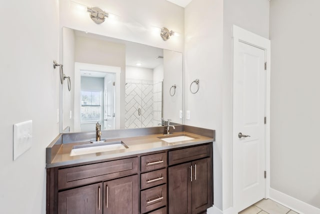 full bathroom with double vanity, tile patterned flooring, baseboards, and a sink