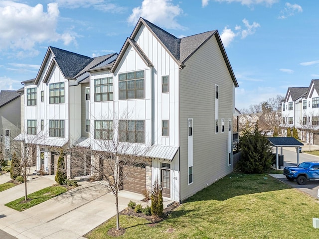 townhome / multi-family property with driveway, a garage, roof with shingles, board and batten siding, and a front yard