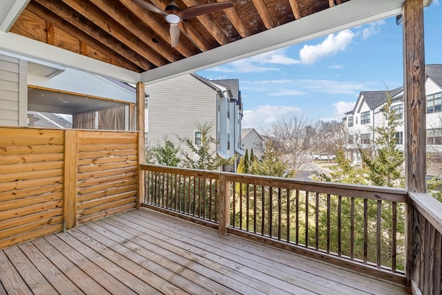 wooden deck with a residential view and ceiling fan