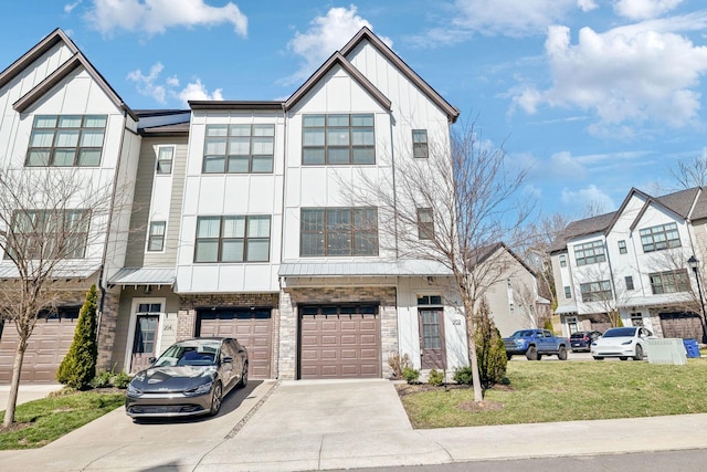 townhome / multi-family property featuring board and batten siding, a front lawn, driveway, and an attached garage