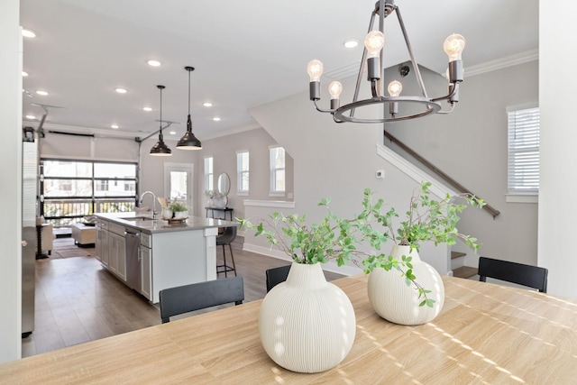 dining space featuring recessed lighting, a notable chandelier, crown molding, and wood finished floors