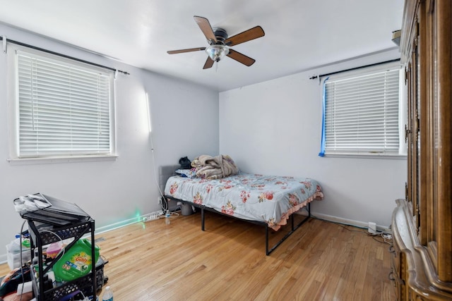 bedroom with ceiling fan, baseboards, and wood finished floors