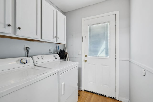 washroom featuring light wood-style floors, washer and dryer, and cabinet space