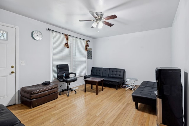 sitting room with light wood-style flooring, baseboards, and a ceiling fan