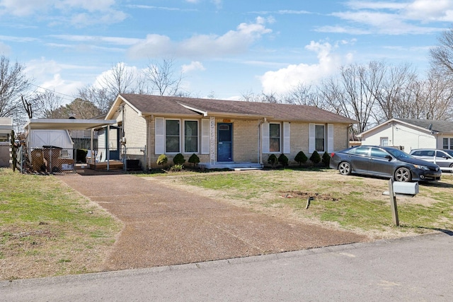 ranch-style home with driveway, brick siding, and a front lawn