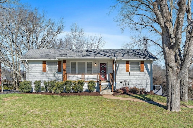 view of front of house featuring a porch, a front lawn, and brick siding