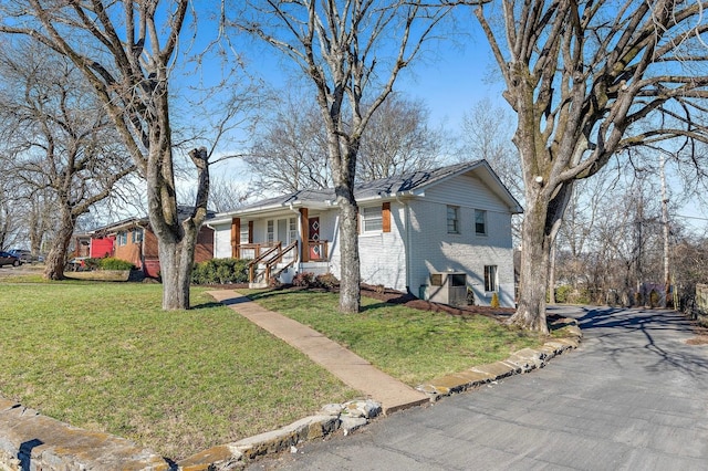 view of front of home with a front yard, covered porch, and brick siding