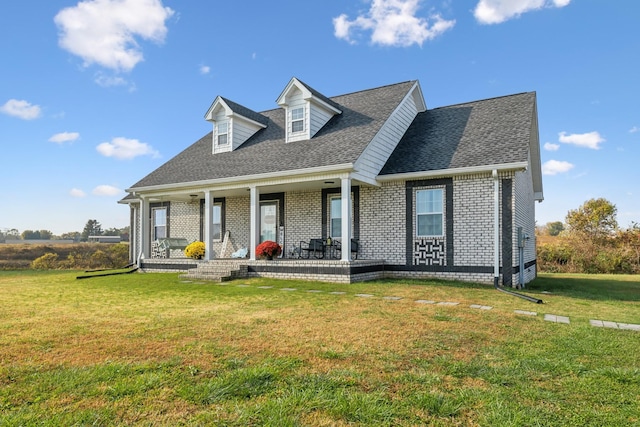 cape cod-style house with roof with shingles, a porch, a front lawn, and brick siding