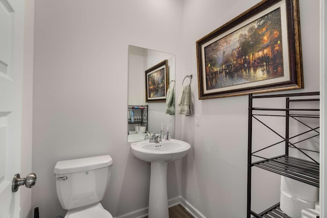 half bath with toilet and baseboards