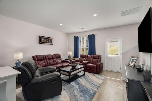 living room featuring light wood-style flooring, visible vents, and recessed lighting