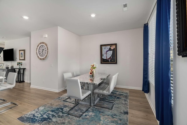 dining area featuring baseboards, visible vents, wood finished floors, and recessed lighting