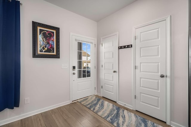 entryway with baseboards and wood finished floors