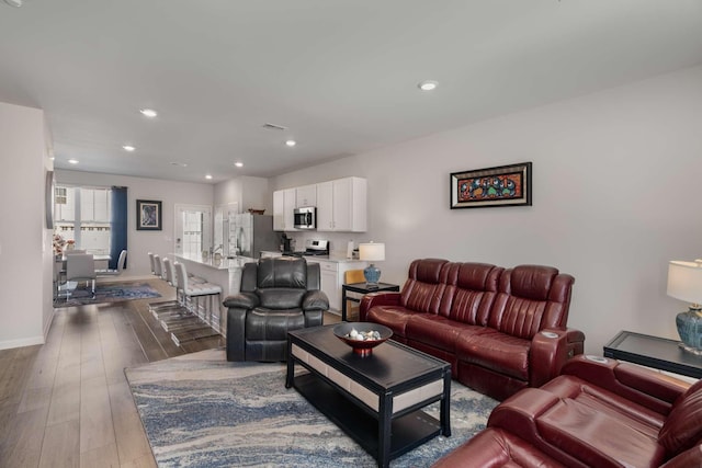 living area featuring dark wood-type flooring, recessed lighting, visible vents, and baseboards