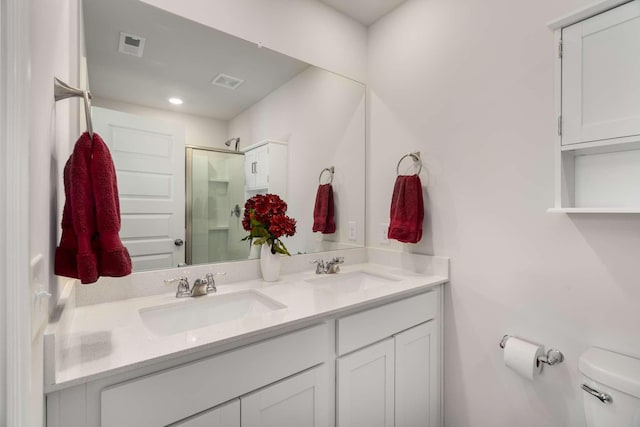 full bath featuring visible vents, a sink, a shower stall, and toilet