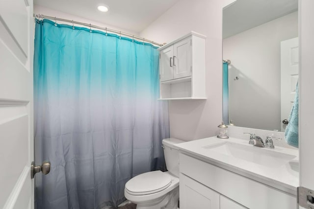 bathroom featuring curtained shower, vanity, and toilet