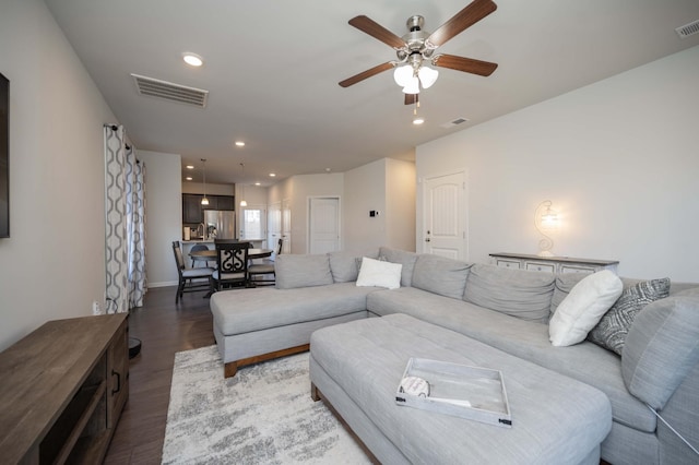 living area featuring a ceiling fan, visible vents, wood finished floors, and recessed lighting