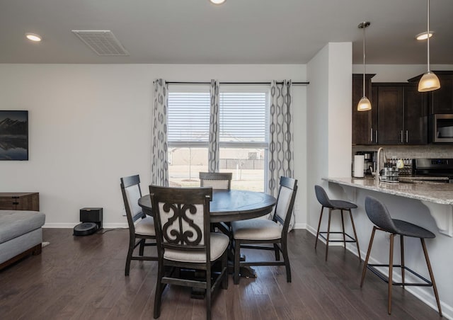 dining room featuring dark wood-style floors, visible vents, and baseboards