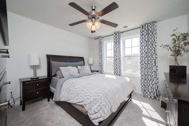 bedroom with light carpet, visible vents, baseboards, and a ceiling fan