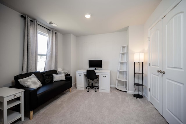 office space with baseboards, visible vents, and light colored carpet