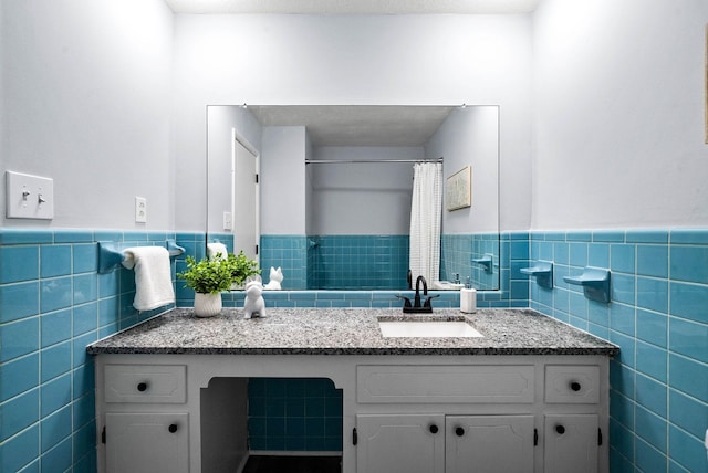 full bath with tile walls, a wainscoted wall, and vanity