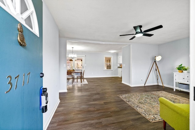 interior space with ceiling fan, baseboards, and dark wood-style flooring