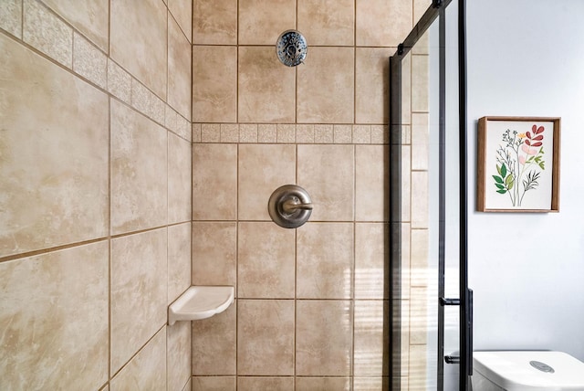 interior details with toilet and tiled shower