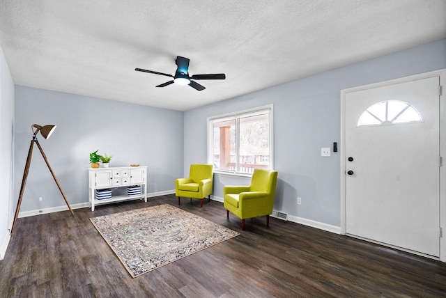 unfurnished room with baseboards, a textured ceiling, visible vents, and dark wood-style flooring