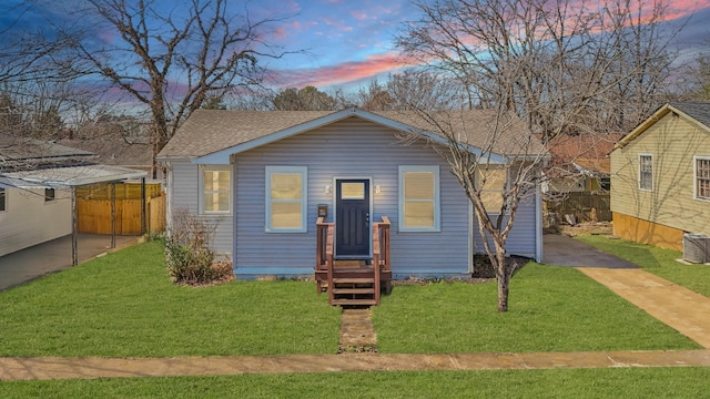 bungalow-style house featuring a shingled roof and a front yard