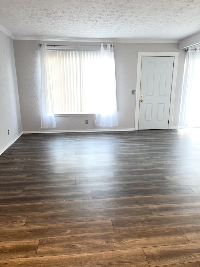 spare room with dark wood-style floors, a textured ceiling, and baseboards