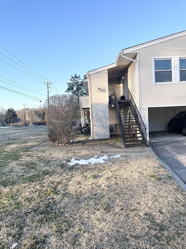 view of side of home featuring driveway and stairs