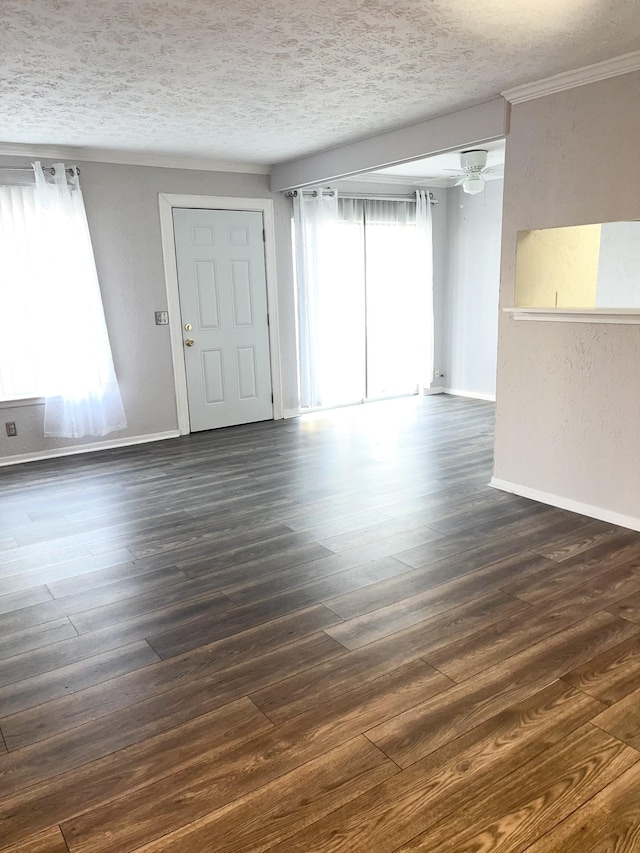 interior space with a ceiling fan, dark wood-style flooring, a textured ceiling, and baseboards