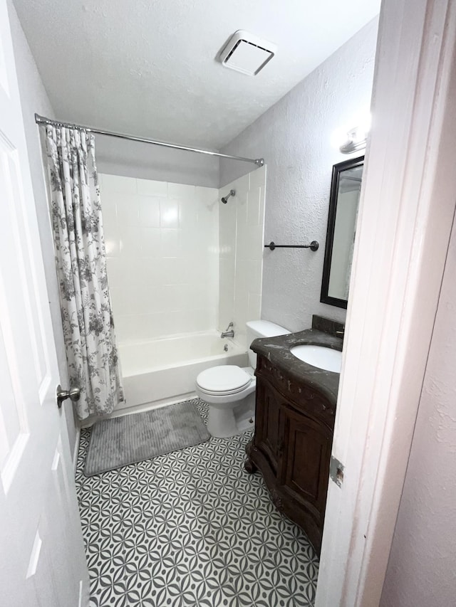 bathroom with shower / bath combination with curtain, a textured wall, toilet, vanity, and a textured ceiling