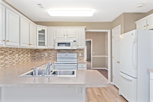 kitchen with white appliances, white cabinetry, light countertops, tasteful backsplash, and glass insert cabinets