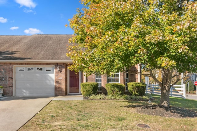 view of front of house featuring brick siding, an attached garage, fence, driveway, and a front lawn