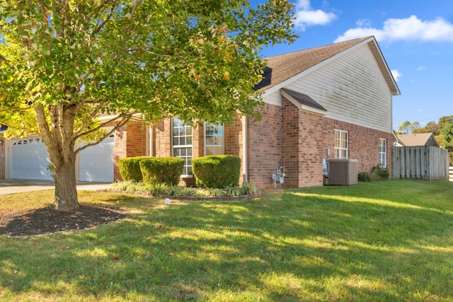 view of side of property featuring concrete driveway, fence, a yard, central air condition unit, and brick siding