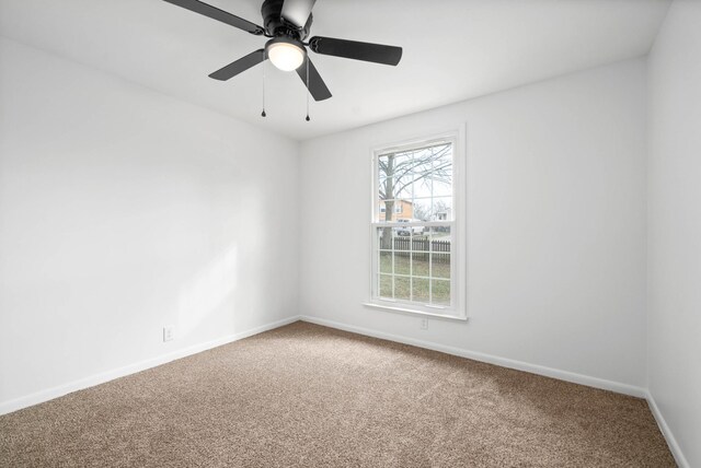 carpeted empty room with baseboards and a ceiling fan