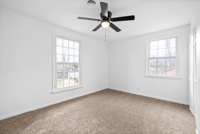 unfurnished room with a ceiling fan, carpet flooring, visible vents, and baseboards