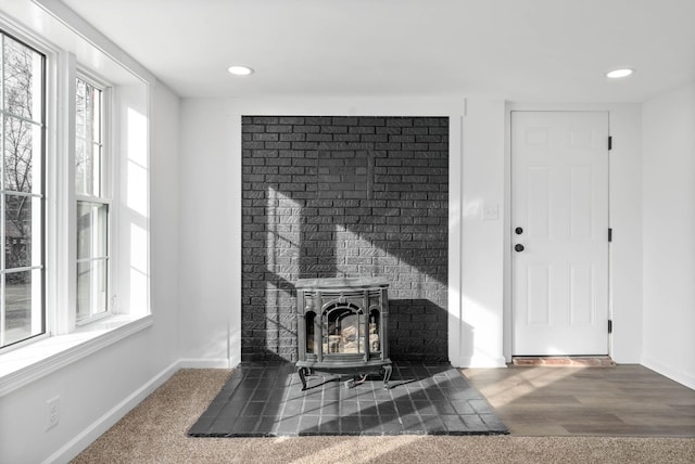 room details with recessed lighting, wood finished floors, a wood stove, and baseboards