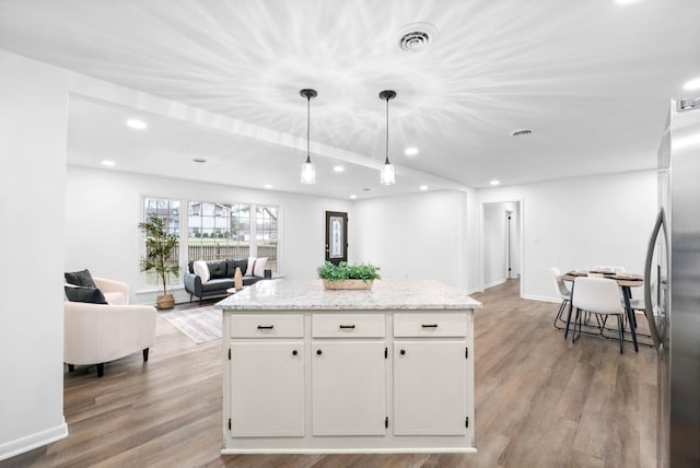 kitchen featuring open floor plan, light wood-style floors, freestanding refrigerator, and white cabinets