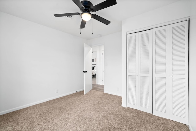 unfurnished bedroom featuring a ceiling fan, baseboards, a closet, and light colored carpet