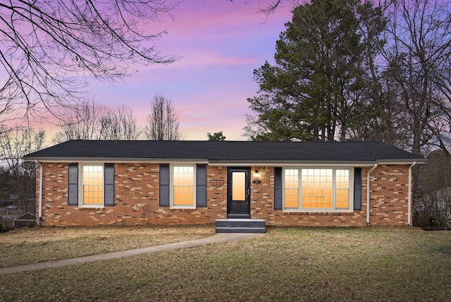 ranch-style house with a front lawn and brick siding