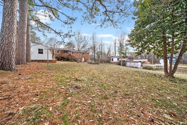 view of yard featuring stairway and fence